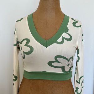 Long sleeved cream colored top with green flowers.